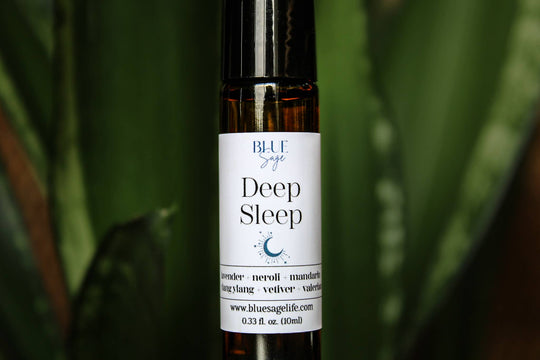 Roll-on bottle labeled 'Deep Sleep' by Blue Sage with a green leafy background
