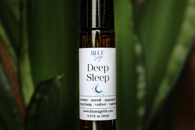 Roll-on bottle labeled 'Deep Sleep' by Blue Sage with a green leafy background