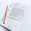 Open book with a pencil on a white background