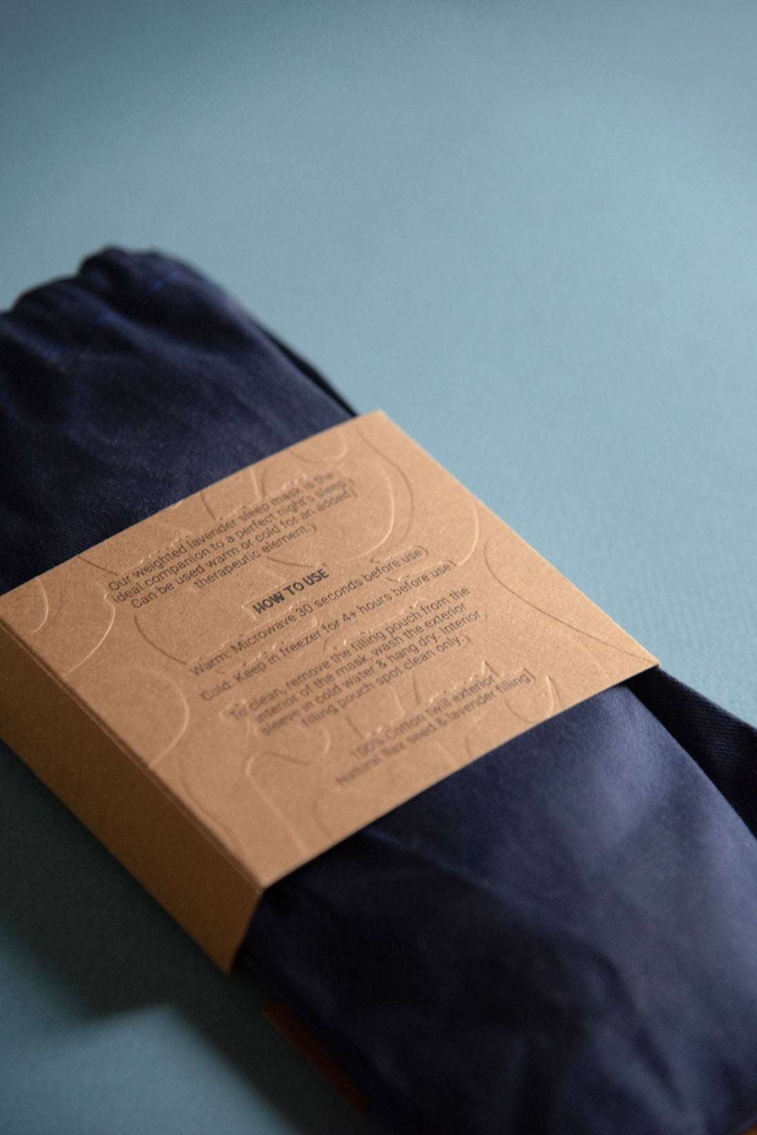 Navy blue fabric with a brown label on a light blue background