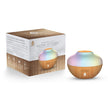An essential oil aroma diffuser with a colorful, multicolored glass container and a wooden base, displayed next to its packaging box.